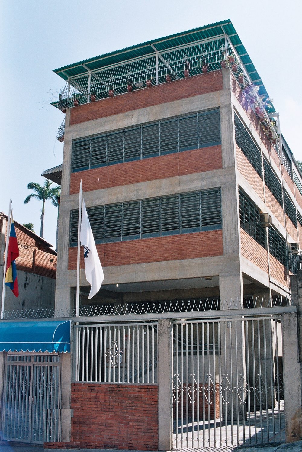 Edificio del Colegio Promesas Patrias con las banderas y el toldo azul